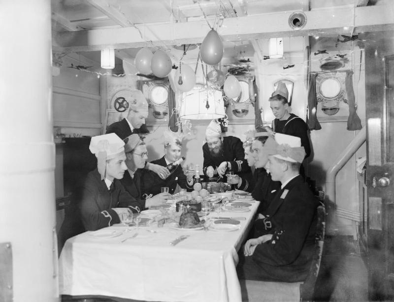 In the ward room that has been decorated with balloons and streamers, the First Lieutenant carves the joint during Christmas celebrations on board HMS WESTMINSTER at Rosyth