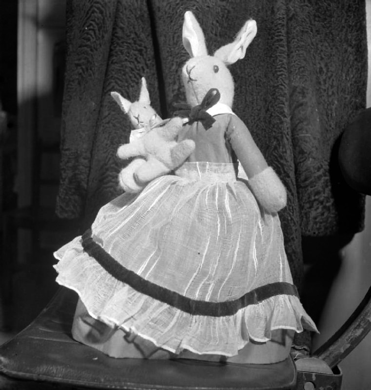 Make-do Dolls For Christmas- Wartime Recycling, 1943 A portrait of a home-made stuffed cloth 'Mrs Brer Rabbit' and baby. According to the original caption, the apron of this children's toy was made from part of an old net curtain