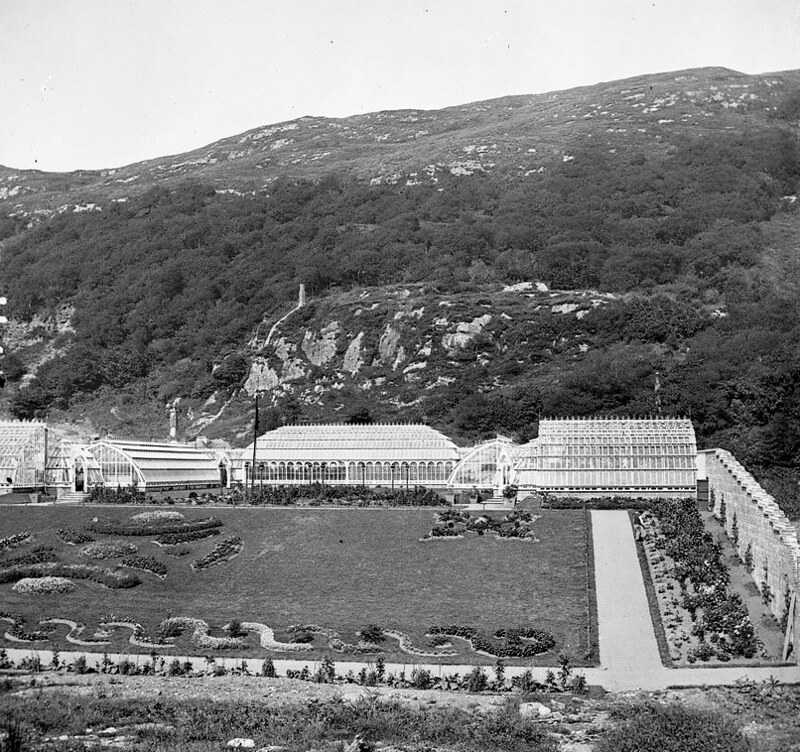 Ornamental garden surrounded by brick wall and six iron framed glass-houses