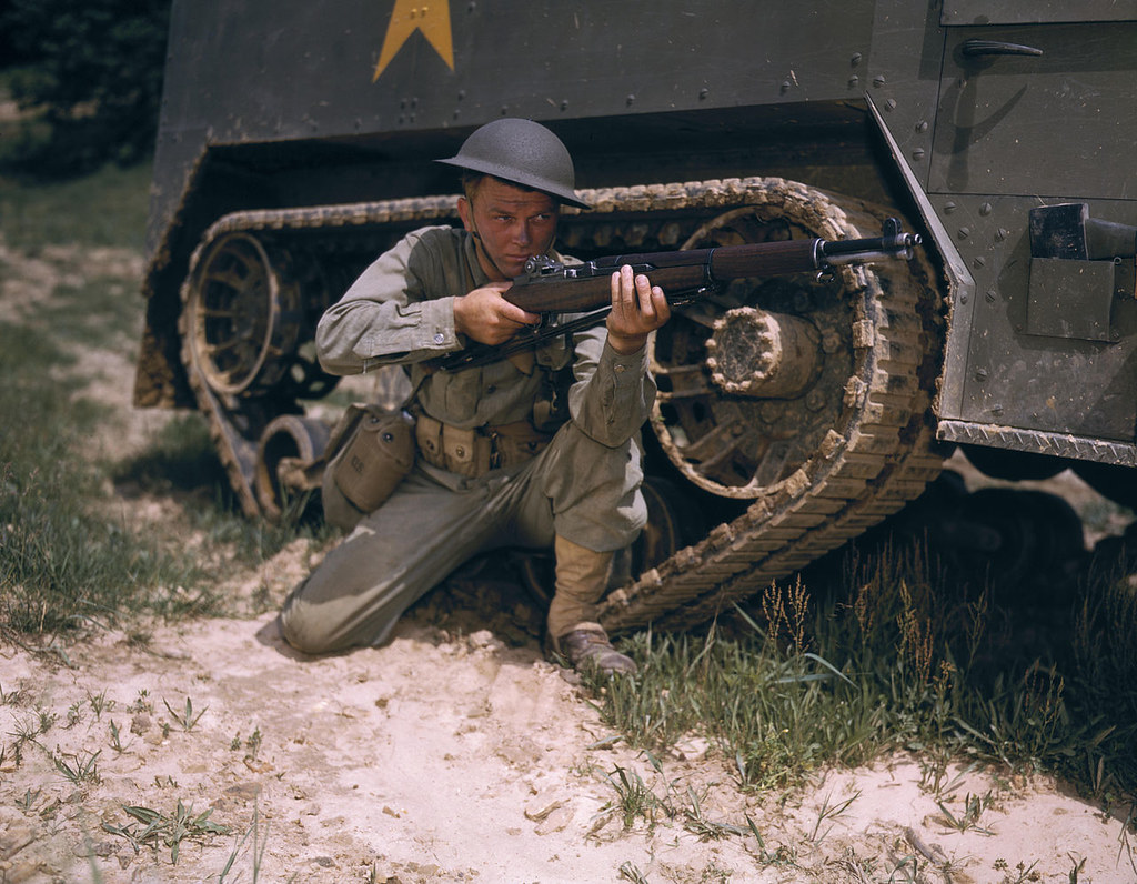 A young soldier of the armored forces holds and sights his Garand rifle like an old timer, 1942