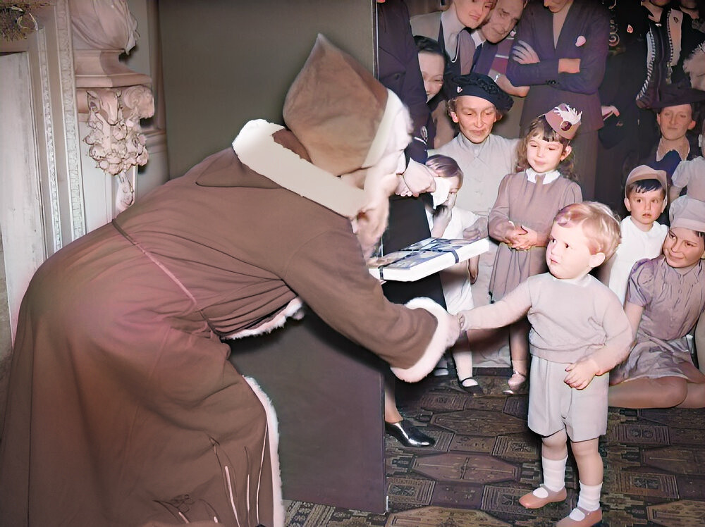 Father Christmas presents Winston Churchill Jr., the Prime Minister's grandson, with a gift at a Christmas party at Admiralty House in London, 17 December 1942