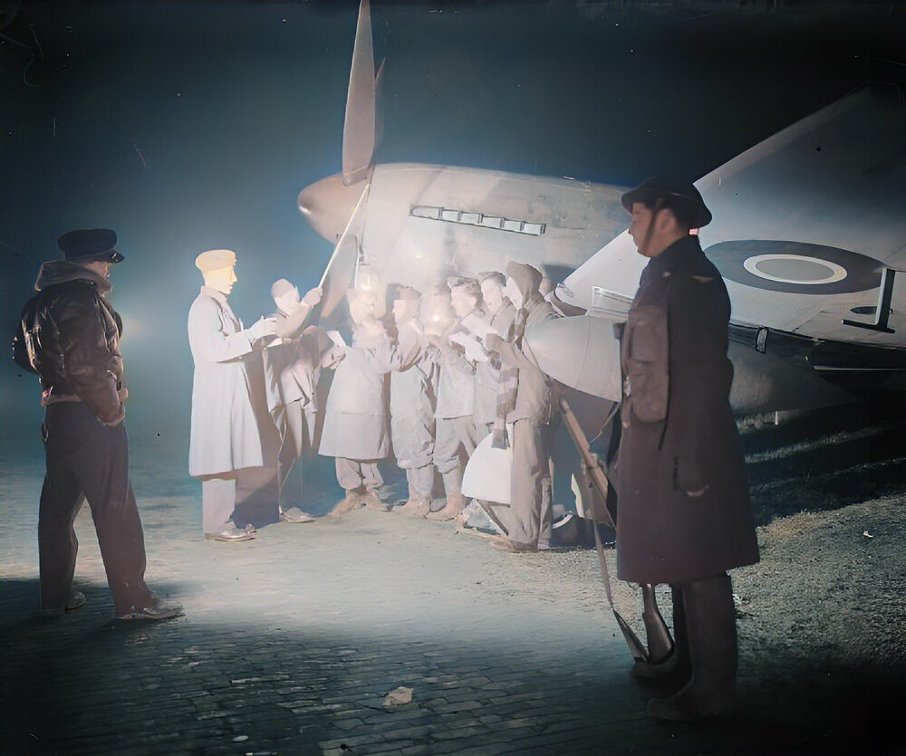 The ground crew of No. 122 Wing singing Christmas carols by a Hawker Tempest in a dispersal at Volkel airfield (B80), Holland 1944