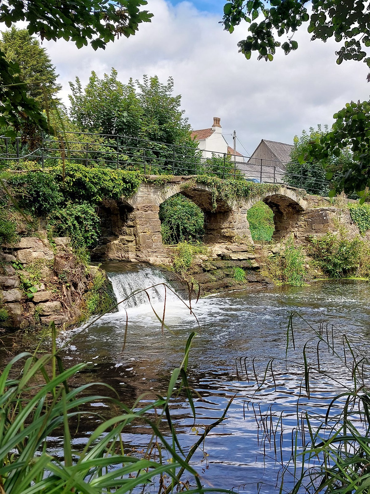 Old stone clapper bridge across the River Chew in Pensford