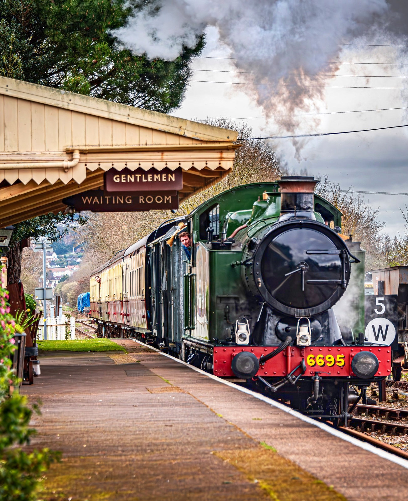 Steam train arriving at Dunster Railway Station